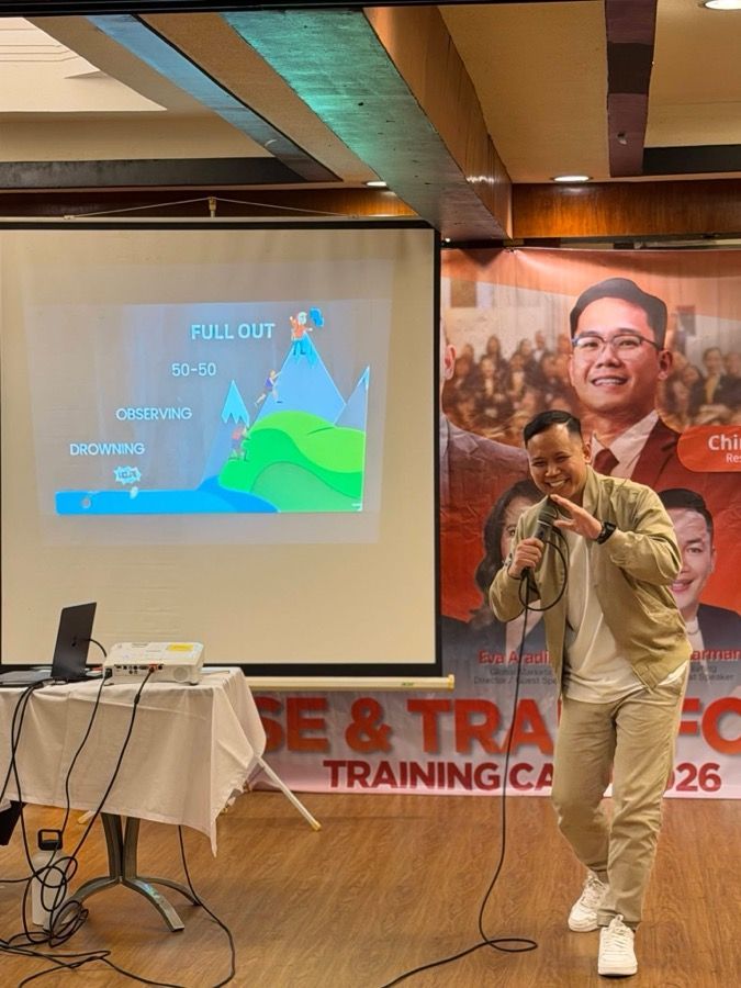 A facilitator on stage at a training camp